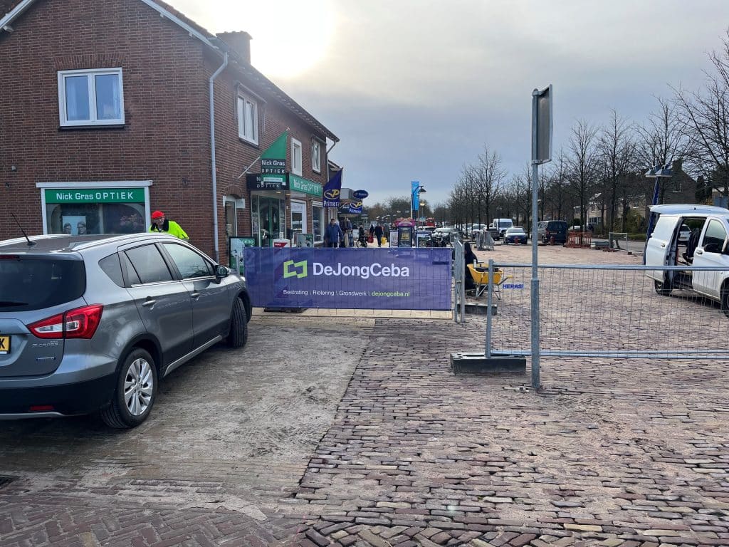 Lage hekken om te voorkomen dat auto's op het nieuwe straatwerk rijden.