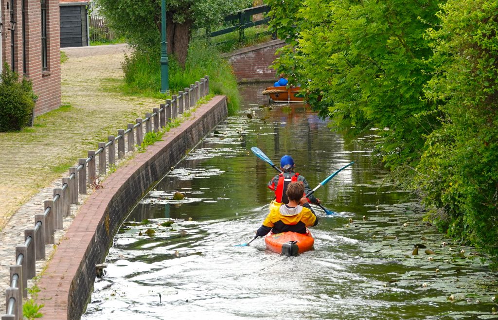 Kajakkers in het water bomen en weg