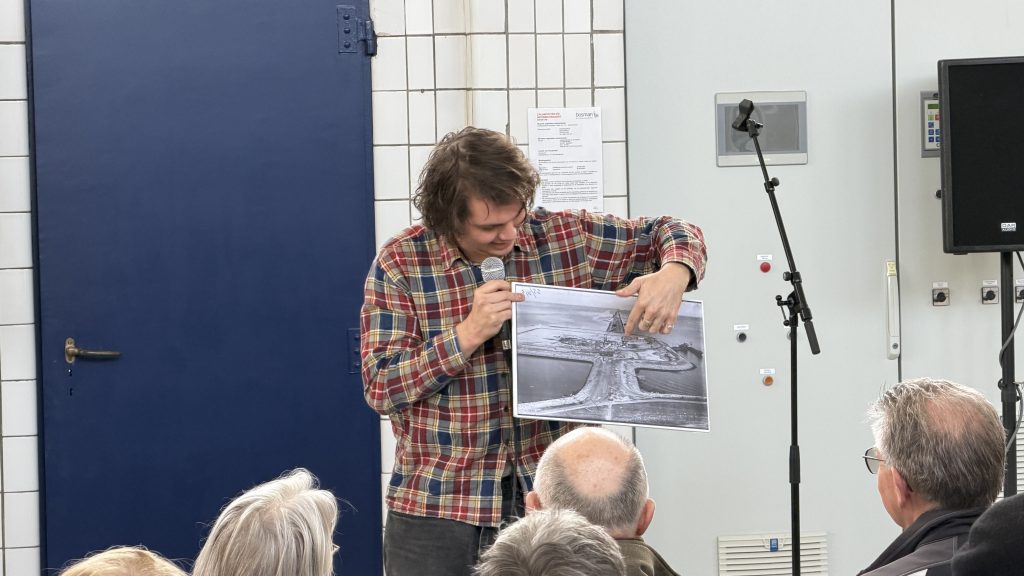 Man legt uit aan de hand van een oude foto