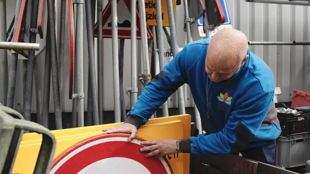 Mannelijke collega aan het werk met verkeersborden