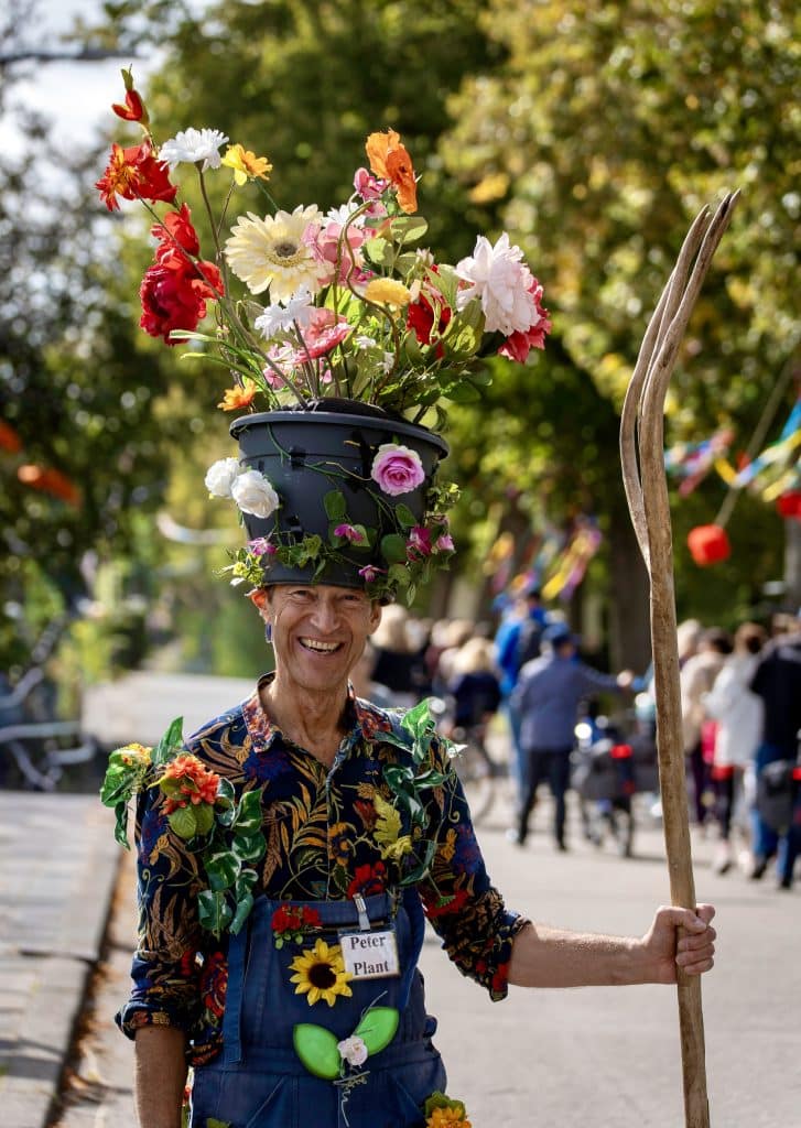 Kleurrijk versierd persoon met bloemen tijdens de Floralia Nieuwe Niedorp