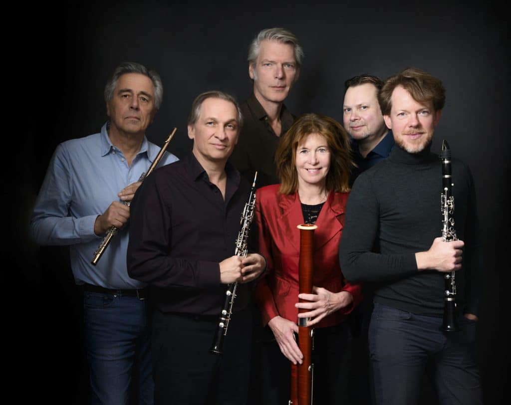Het Hexagon ensemble poseert met hun instrumenten samen voor een foto