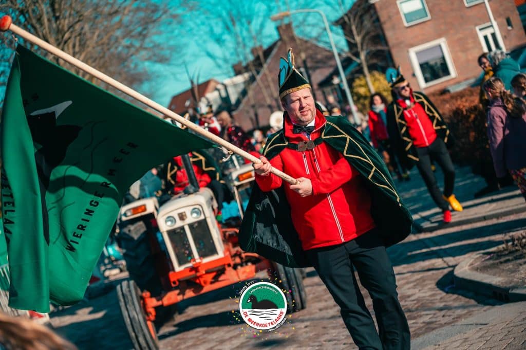 Optocht tijdens Carnaval C.V. De Meerkoetelaars met een vlaggendrager