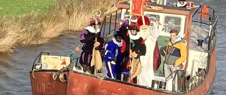 Sinterklaasintocht Van Ewijcksluis. Foto van de stoomboot met de sint en pieten die richting de camera vaart